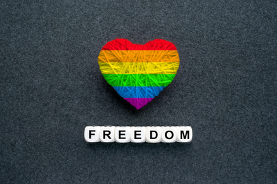 Rainbow colored hart and the words freedom below it.