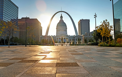 Photo of the arch in St. Louis with buildings around it.