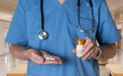 Medical doctor holding a pill bottle.