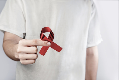 Person holding a red ribbon.