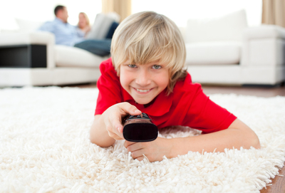 Young boy using a tv remote.