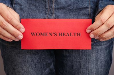 Person holding a sign labeled Women's health.