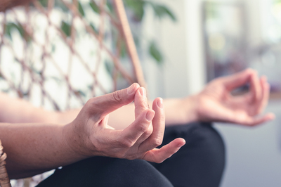 Person holding their hands in a meditative position.