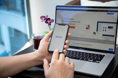 Zoom app displayed on a phone and laptop.
