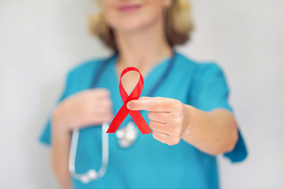 Medical professional holding a red ribbon.