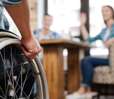 Person in a wheelchair greeting a group