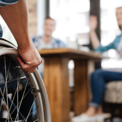 Person in a wheelchair greeting a group
